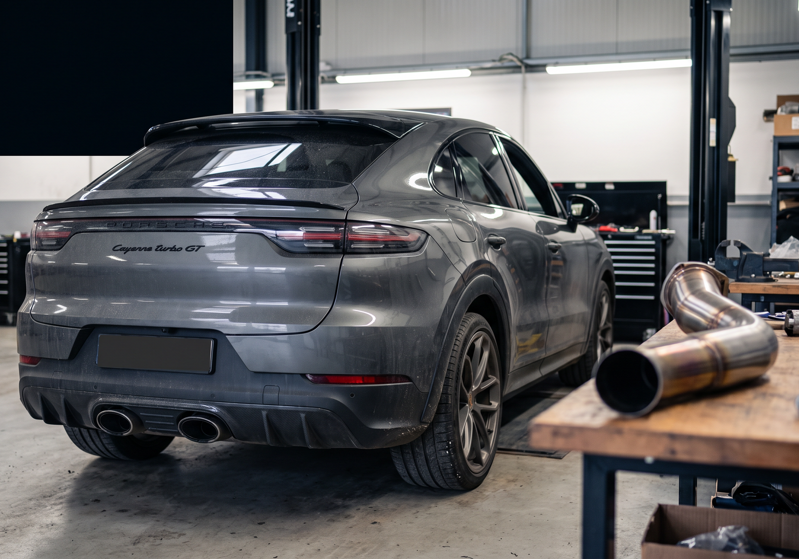 Porsche Cayenne Turbo GT in a workshop with exhaust and downpipe components for a buyer guide