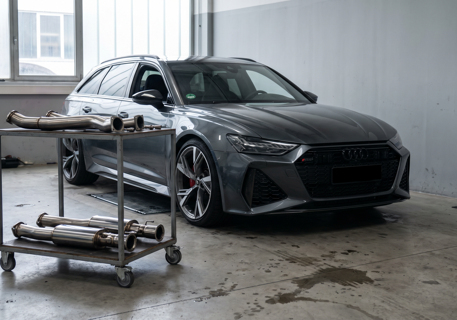 Grey Audi RS6 Avant C8 in a workshop with stainless downpipe sections for an RS6/RS7 downpipes guide