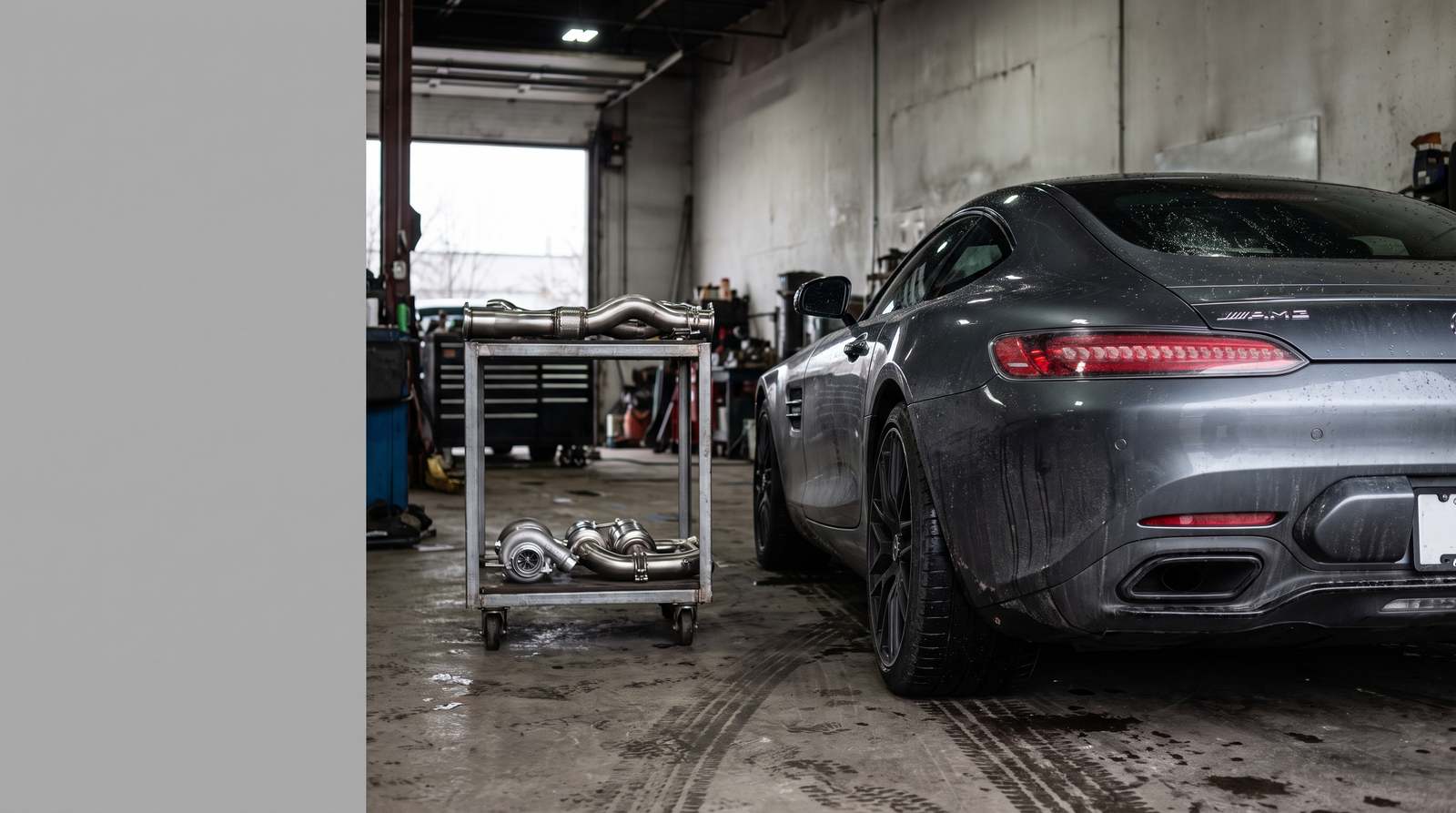 Illustration: dark Mercedes-AMG GT-style coupe in a workshop with downpipe and exhaust components for a fitment guide