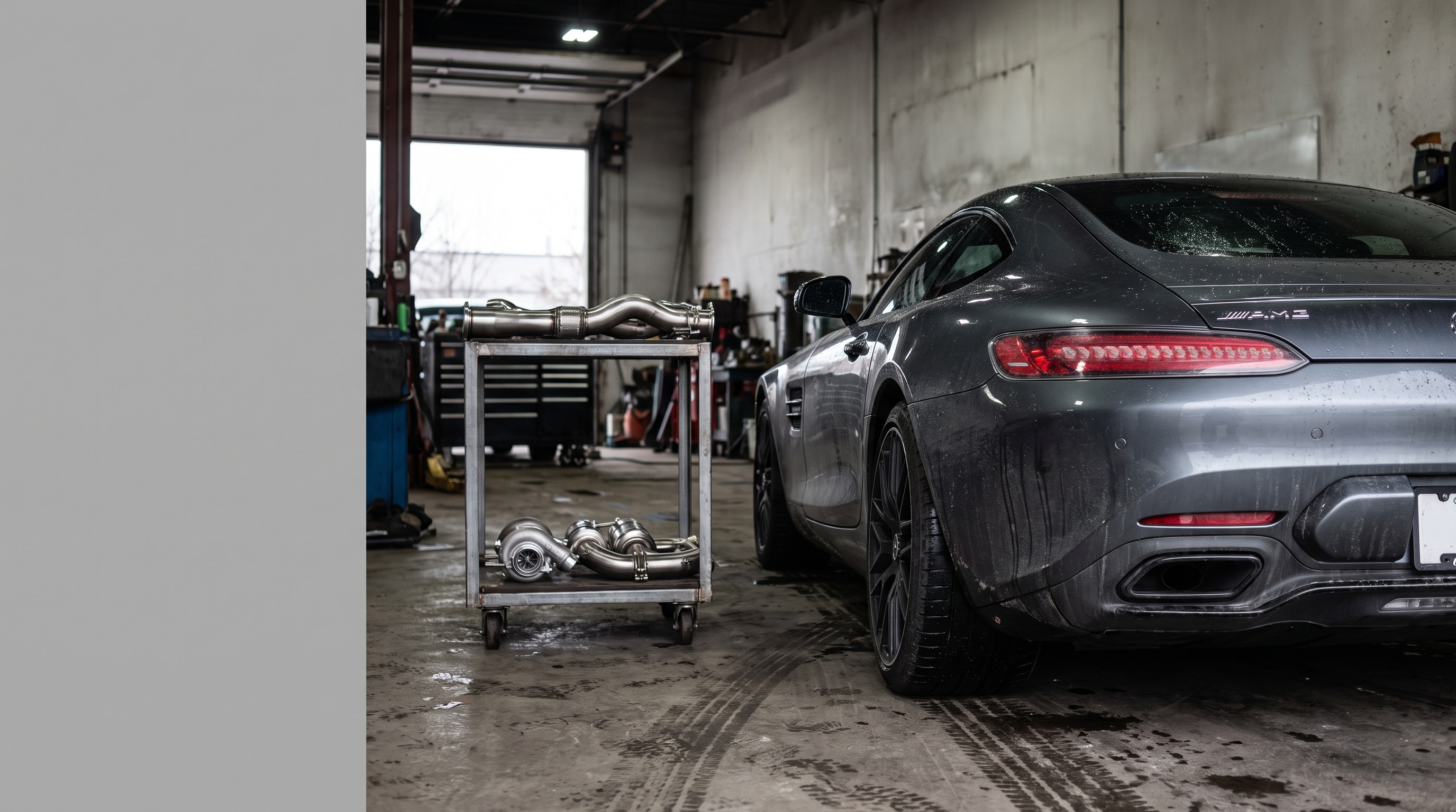 Illustration: dark Mercedes-AMG GT-style coupe in a workshop with downpipe and exhaust components for a fitment guide